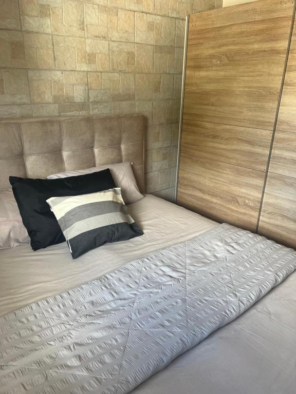 łóżko z zagłówkiem i poduszkami w obiekcie Theodore resort w mieście Áyios Yeóryios