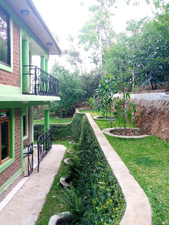 a house with a walkway next to a yard at Galapagos Homestay in Lushoto