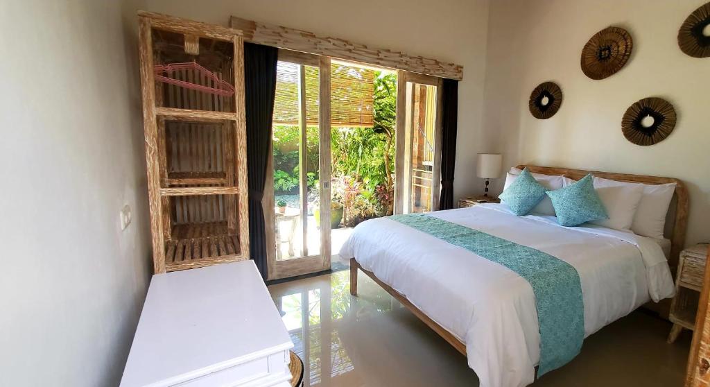 1 dormitorio con 1 cama y puerta corredera de cristal en Your Secret Garden Villa - Melasti Beach! en Ungasan