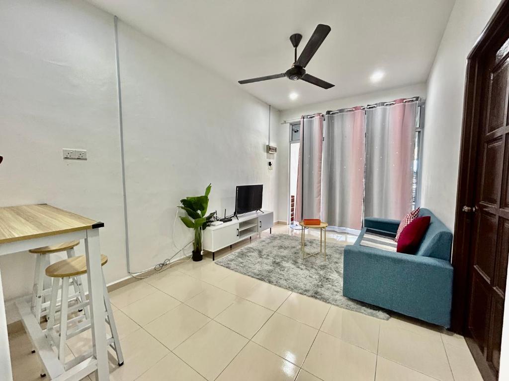 a living room with a blue couch and a tv at Cozy288#4pax#wifi#NearAeonAlma,Mcd#2kmtoIconicPoint in Bukit Mertajam