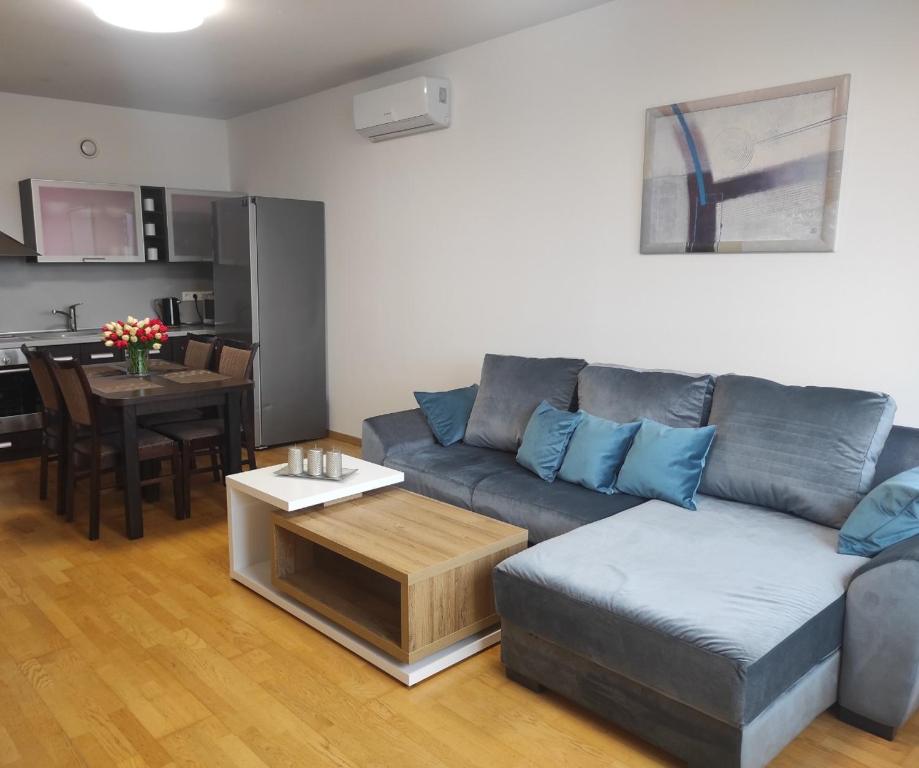 a living room with a couch and a table at Klaipėdos 99 Apartamentai in Panevėžys