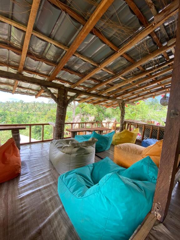 a covered porch with several bean bags on the floor at Tetebatu Sama Sama Bungalows in Tetebatu