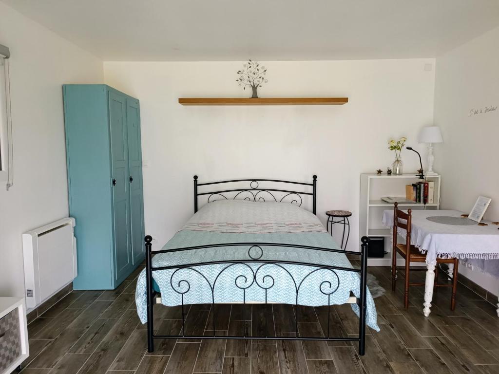 a bedroom with a bed and a table and a desk at Le Petit Accent in Saint-Pierre-de-Bailleul