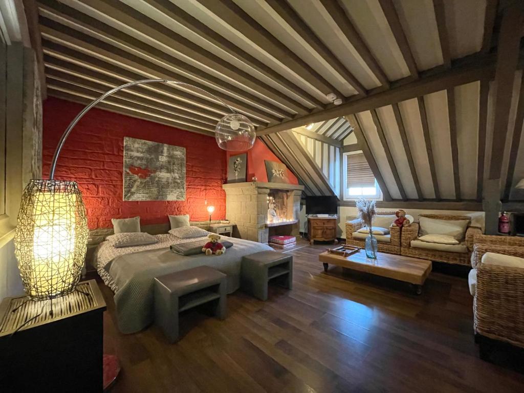 une chambre avec un grand lit et un salon dans l'établissement Au coeur de Sainte Catherine, à Honfleur