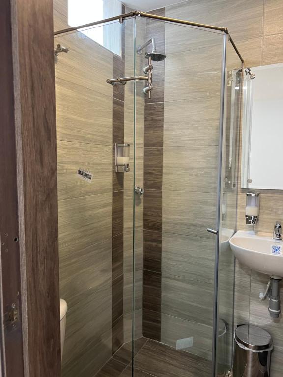 a bathroom with a glass shower and a sink at Hotel boutique bussines center in Cali