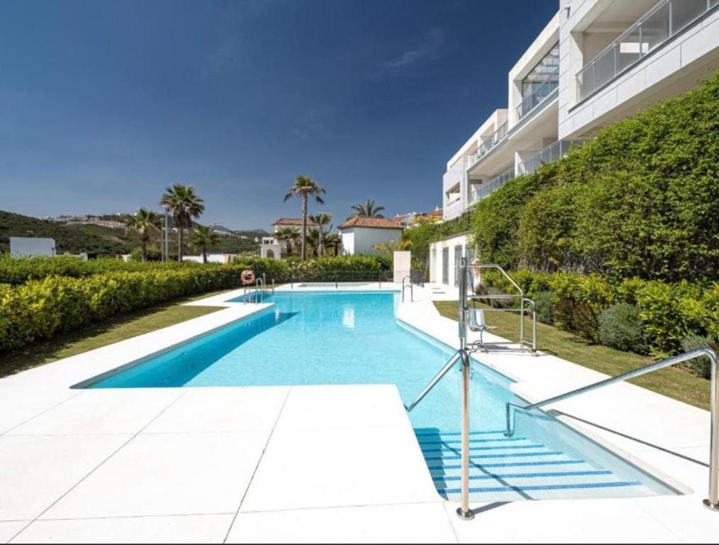 a swimming pool in front of a building at Appartement Casares - Mer, Golf, Piscine, Padel - FINCA CORTESIN in Estepona