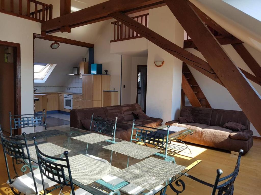 a living room with a glass table and a couch at Chaleureux duplex en Alsace in Mulhouse