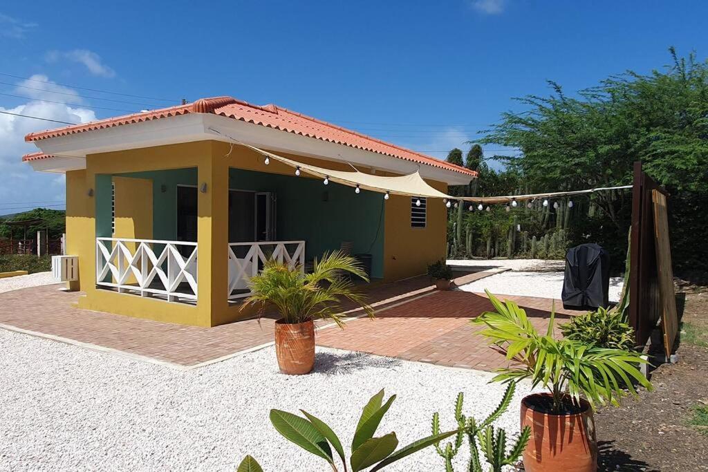 a small yellow and green house with plants in front of it at Local Willibrord Lodge in Willibrordus