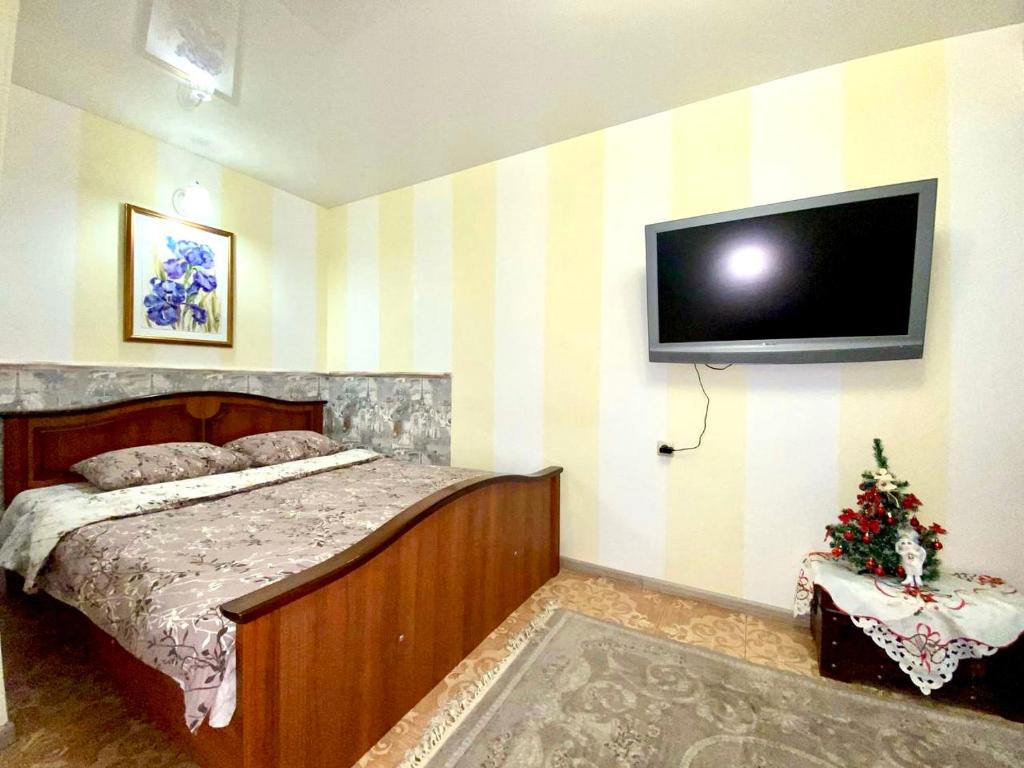 um quarto com uma cama e uma televisão de ecrã plano em 1-кімн Французький шик у центрі Полтави ,Корпусний парк em Poltava