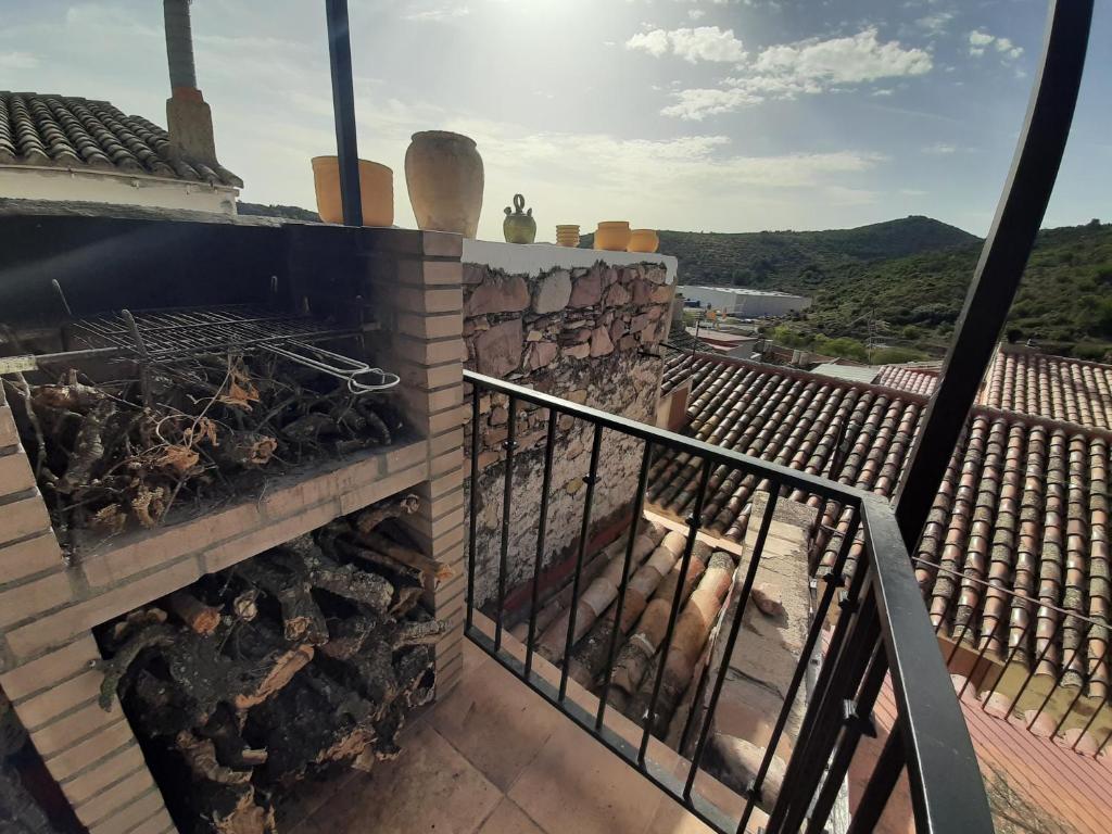 Ático Rural en pareja, amigos o familia a la montaña "EL COLMENAR" في Chóvar: يوجد شواية فوق منزل به جبال في الخلفية