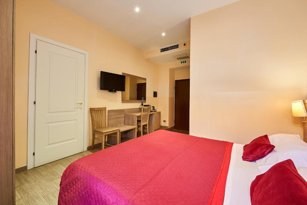 1 dormitorio con 1 cama con manta roja en Catone Vatican Suites en Roma