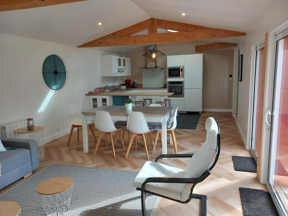a kitchen and living room with a table and chairs at Maison Esprit Des Lois in La Brede
