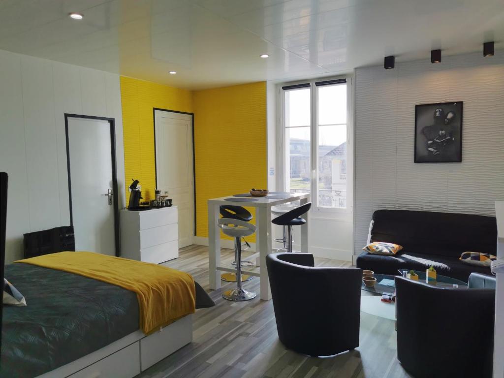 1 dormitorio con cama, escritorio y sofá en VITTEL LOC'S - LE 214, classé 3 étoiles OSEZ L'EXPERIENCE, en Vittel