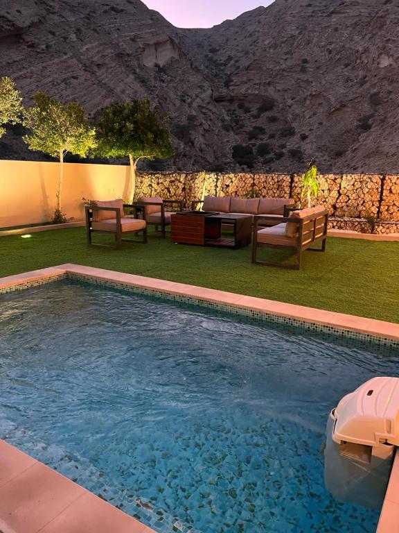 a swimming pool in a yard with a mountain in the background at W muscat bay in Muscat