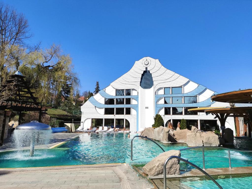 a large building with a swimming pool in front of it at Spa Residence Carbona Silver Deluxe Apartment in Hévíz