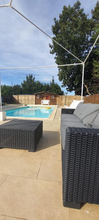 basen z dwoma ławkami przed nim w obiekcie Appartement 3 pièces avec Piscine w mieście La Ferté-Gaucher