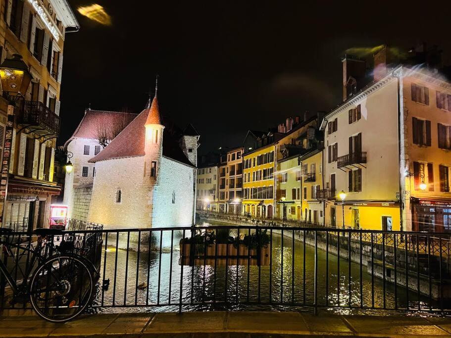 ulica miejska w nocy z budynkami i rowerem w obiekcie Appartement moderne vieille ville PARKING GRATUIT w Annecy