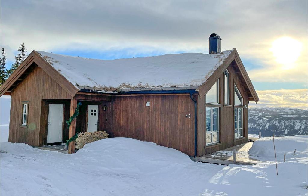 Una pequeña casa en la nieve con el sol detrás. en 3 Bedroom Stunning Home In Aurdal, en Aurdal