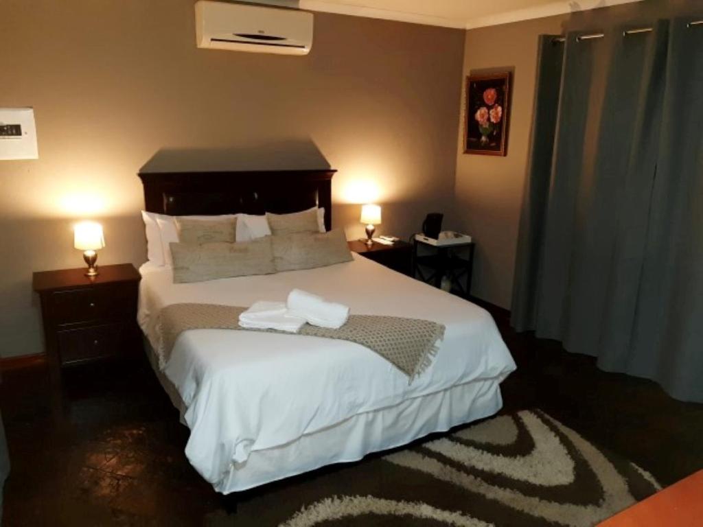 1 dormitorio con 1 cama con 2 toallas en Tapologo Lodge, en Zeerust