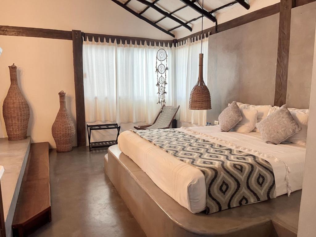 a bedroom with a large bed in a room with vases at Hotel Luna De Plata in Mahahual