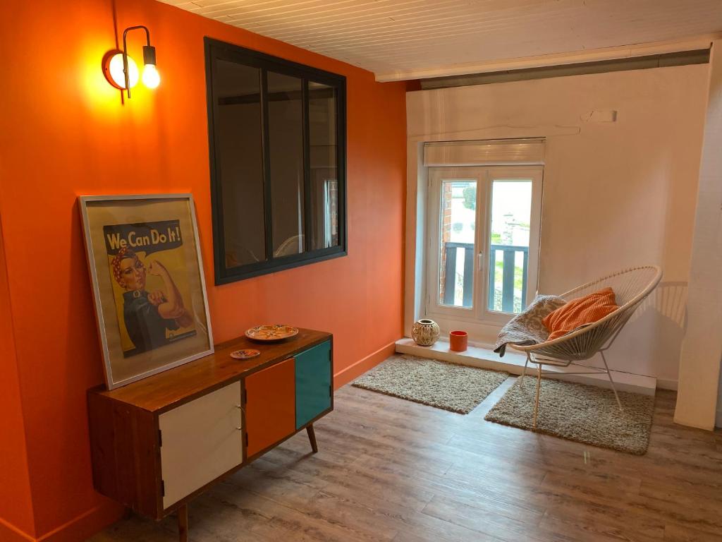 sala de estar con paredes de color naranja y ventana en Sunset Bricqueville sur mer, en Bricqueville-sur-Mer