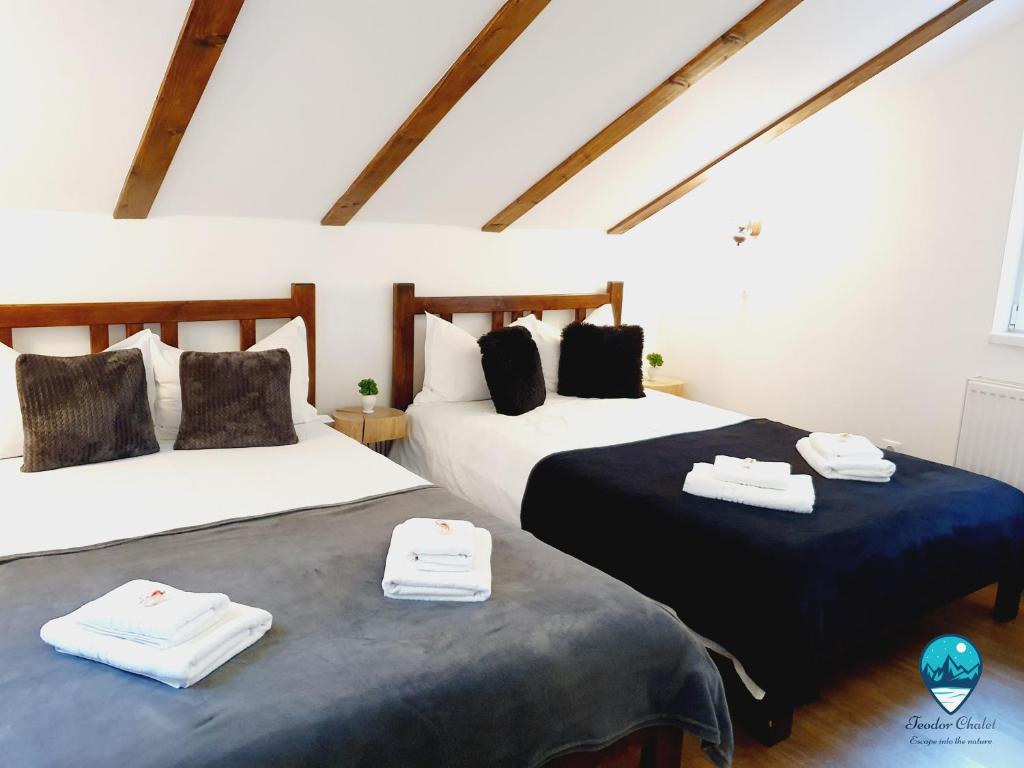 2 camas en una habitación con sábanas blancas y negras en Teodor Chalet, en Avrig