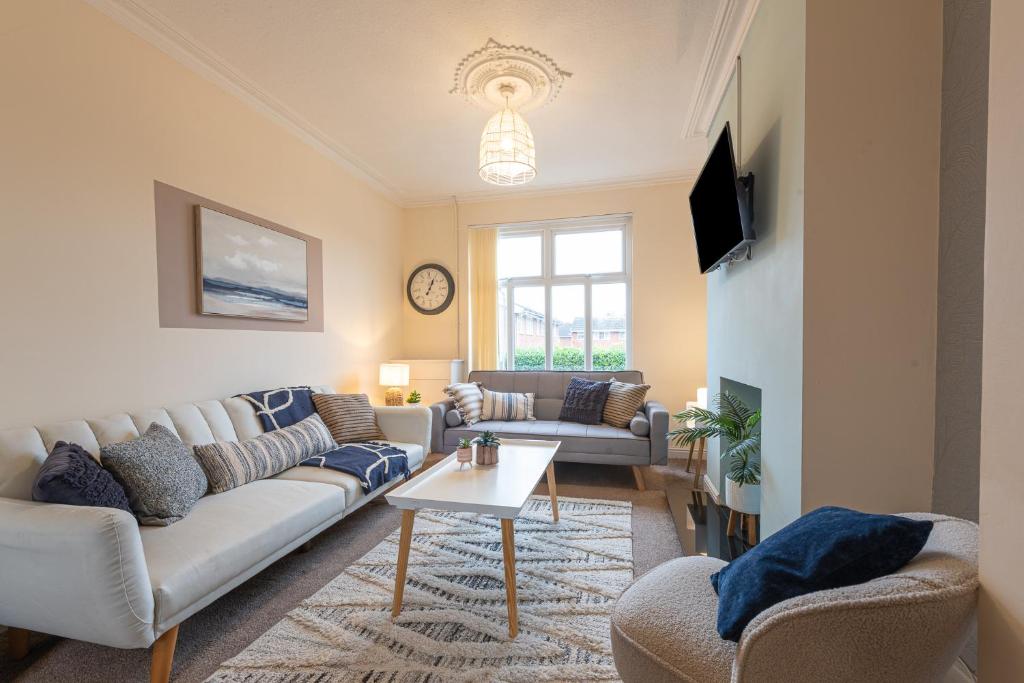 ein Wohnzimmer mit einem Sofa und einem Tisch in der Unterkunft Hope House Chester Sleeps 6 by Heritage Stays in Hough Green