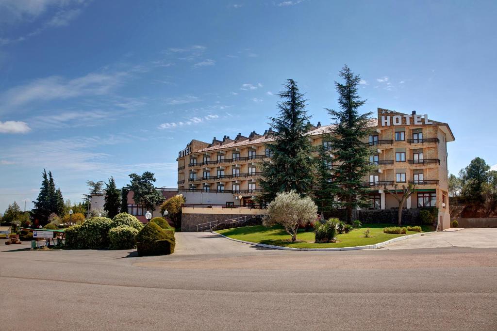 a hotel building with trees in front of it at Hotel Rey Sancho Ramírez in Barbastro