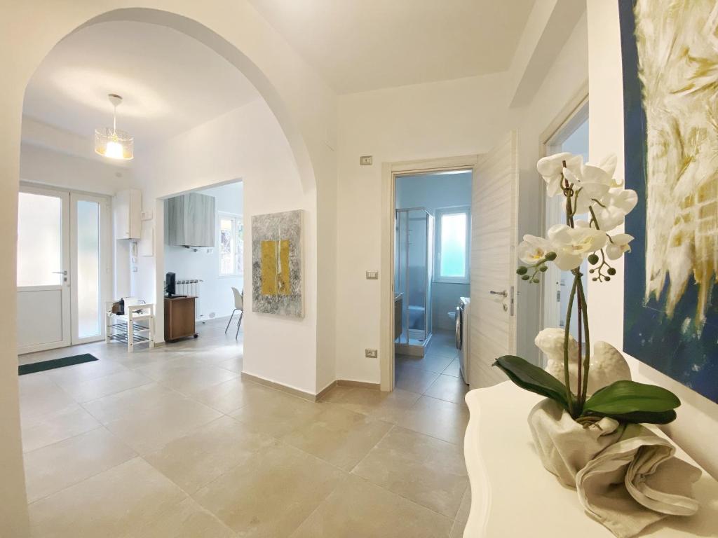 a living room with a vase with white flowers in it at COMFORTABLE SEA HOLIDAYS AND WALKS in Moneglia
