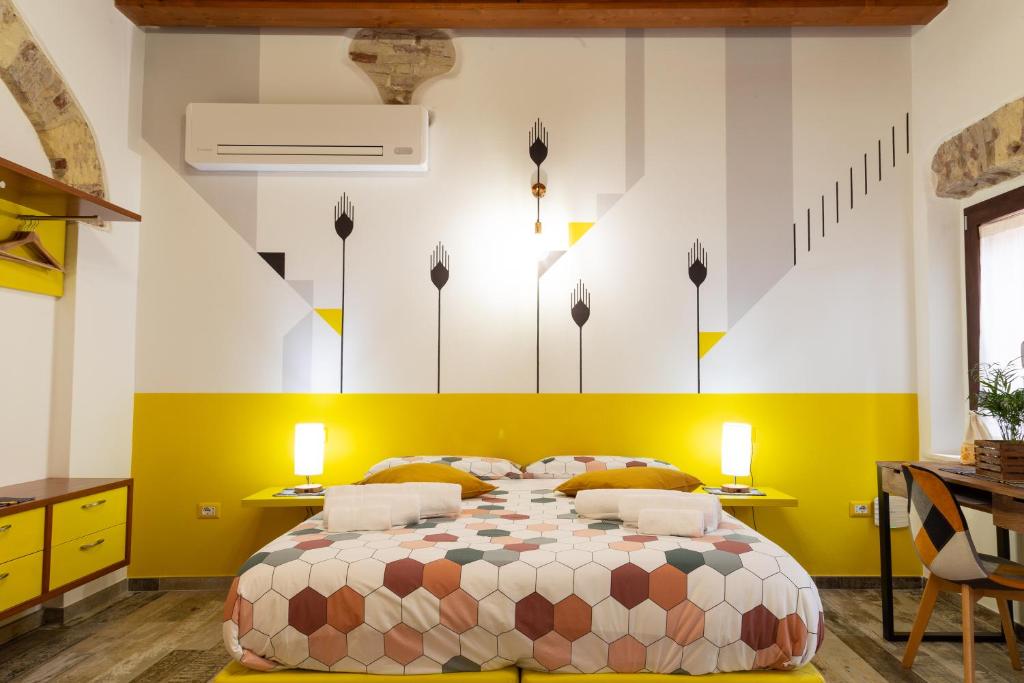 a bedroom with a bed and a yellow and white wall at Trigu & Mangoni in Cagliari