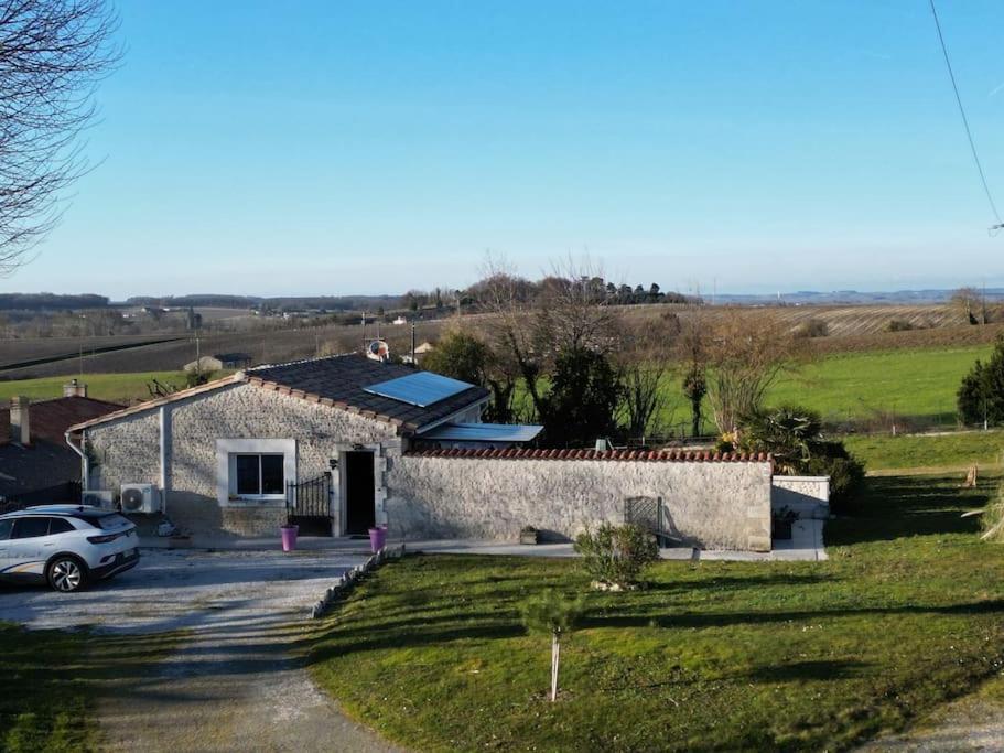 una casa con un coche aparcado delante de ella en Authentique maison en pierre de 160 m2 au calme, en Reignac