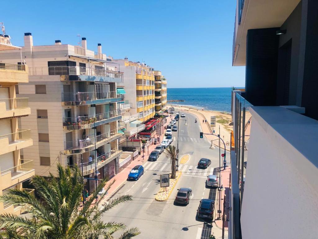 uma vista para uma rua com edifícios e o oceano em Residencial Alegria 12 em Torrevieja