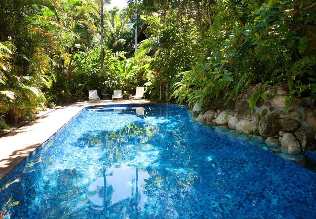 einen Pool inmitten eines Gartens in der Unterkunft Coral Sea Villas in Port Douglas