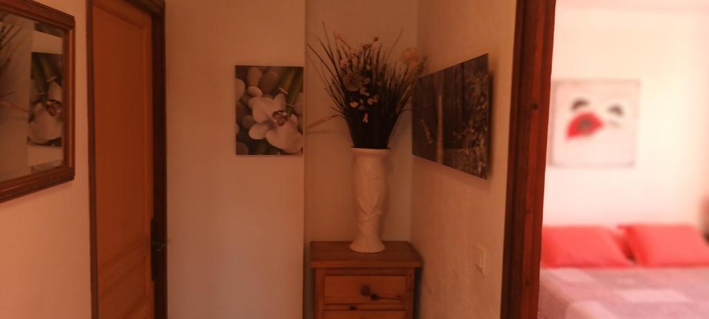 un vase avec des fleurs sur une table dans une pièce dans l'établissement Le panorama, 