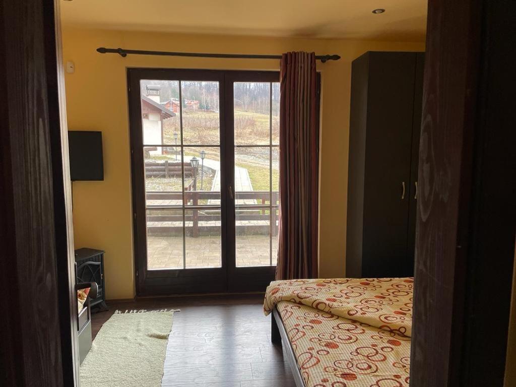 1 dormitorio con puerta que da a un balcón en MIN apartman Goc, en Vrnjačka Banja