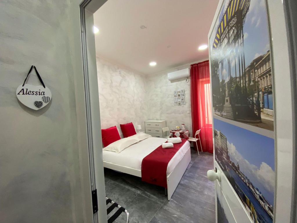 ein Schlafzimmer mit einem Bett mit roten Kissen in der Unterkunft CLALE ROOMS in Neapel