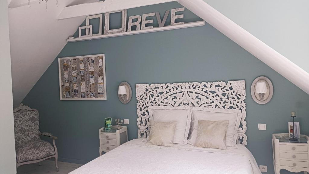 1 dormitorio con cama blanca y pared azul en Les chambres de l'Atelier, en Pont-Aven