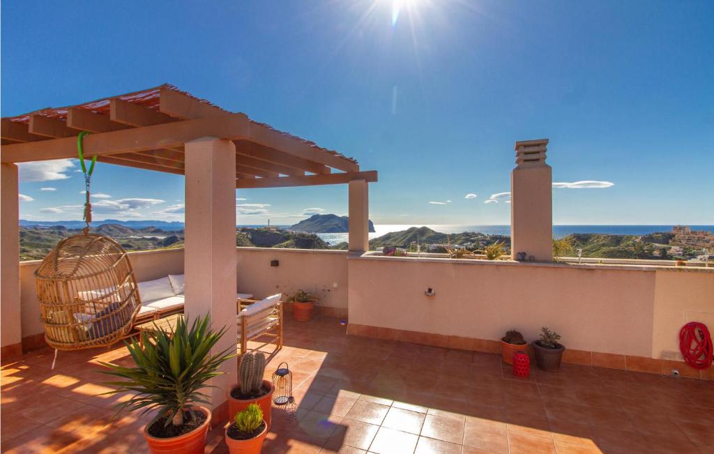 a patio with a pergola and chairs on a roof at 2 Bedroom Gorgeous Apartment In guilas in Águilas