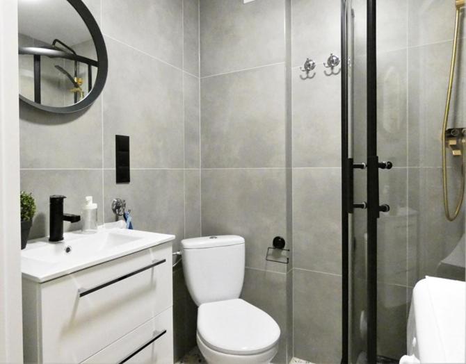 a bathroom with a shower and a toilet and a sink at Hola Apartamenty Legionow in Łódź