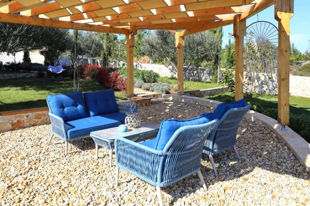 um pátio com 2 cadeiras azuis e uma mesa em Modern House Giulia em Dobropoljana