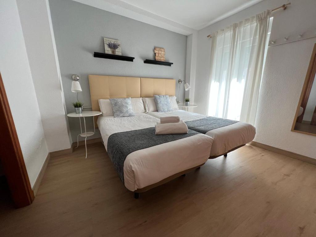 ein Schlafzimmer mit einem großen Bett und einem großen Fenster in der Unterkunft APN Hatabin in Granada