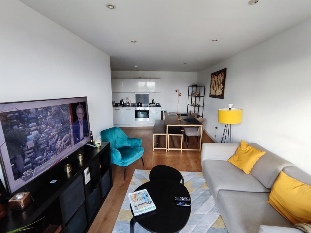 a living room with a couch and a flat screen tv at Spacious & Serene Stay in London in Forest Hill