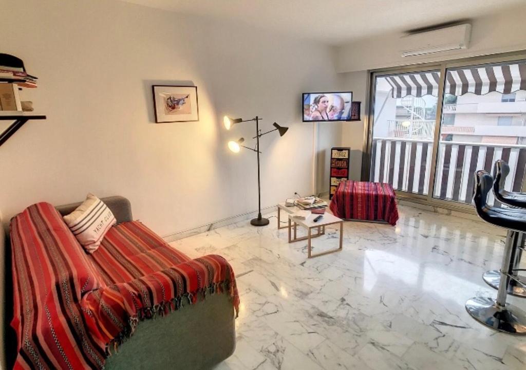 uma sala de estar com um sofá e uma televisão em Superbe Studio tout équipé/Proche mer et commodité em Saint-Laurent-du-Var