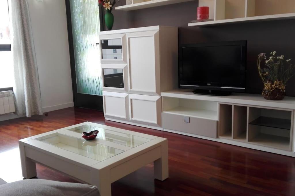 uma sala de estar com uma televisão e uma mesa de centro em Grande, luminoso y con garage, 3 dormitorios en el camino de Santiago em Burgos