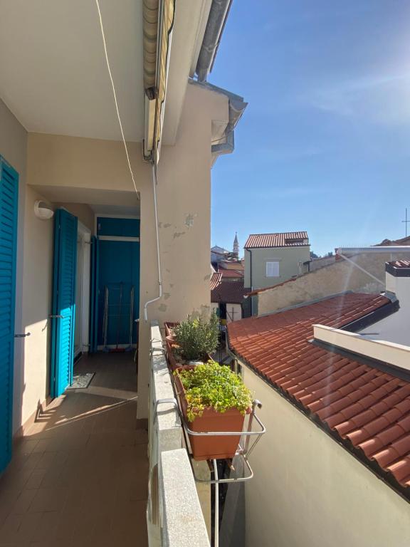 un balcón con macetas en un edificio en Lucy Apartment Piran-Punta, en Piran