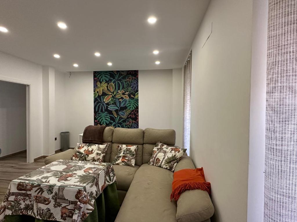 - un salon avec un canapé et un lit dans l'établissement Alamos Suite, à Jaén