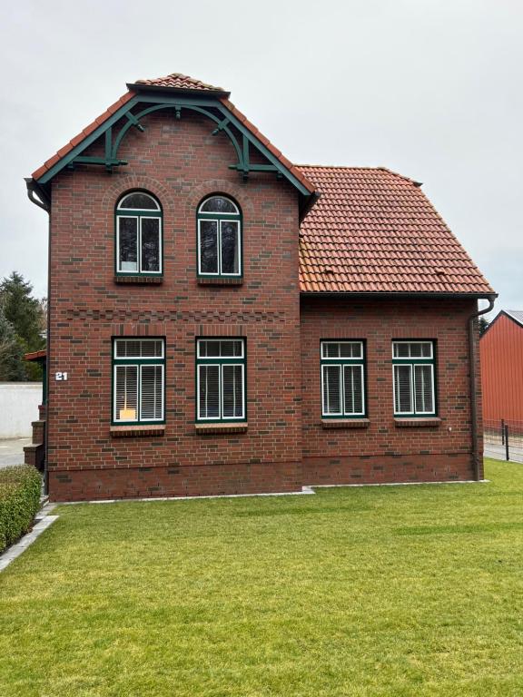 una casa de ladrillo rojo con ventanas en el césped en Ferienwohnung in Bad Bramstedt en Bad Bramstedt