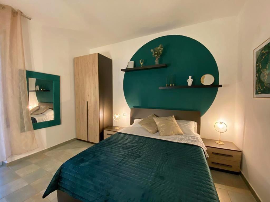 um quarto com uma cama com uma cabeceira verde em Villa Boeddu, relax tra mare e campagna em Alghero