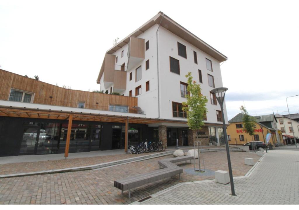 a building on a street with bikes parked in front of it at Apartman 22, Rezidence & Wellness Javor in Železná Ruda