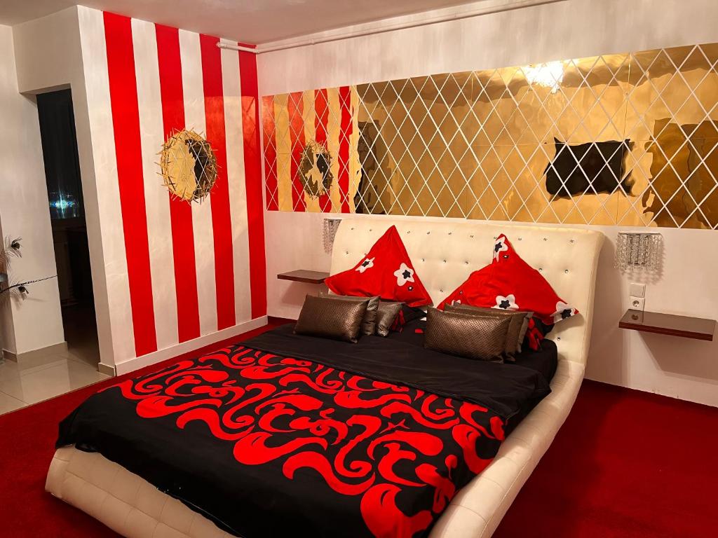 a bedroom with a large bed with red pillows at Garsoniera Mihaela in Deva